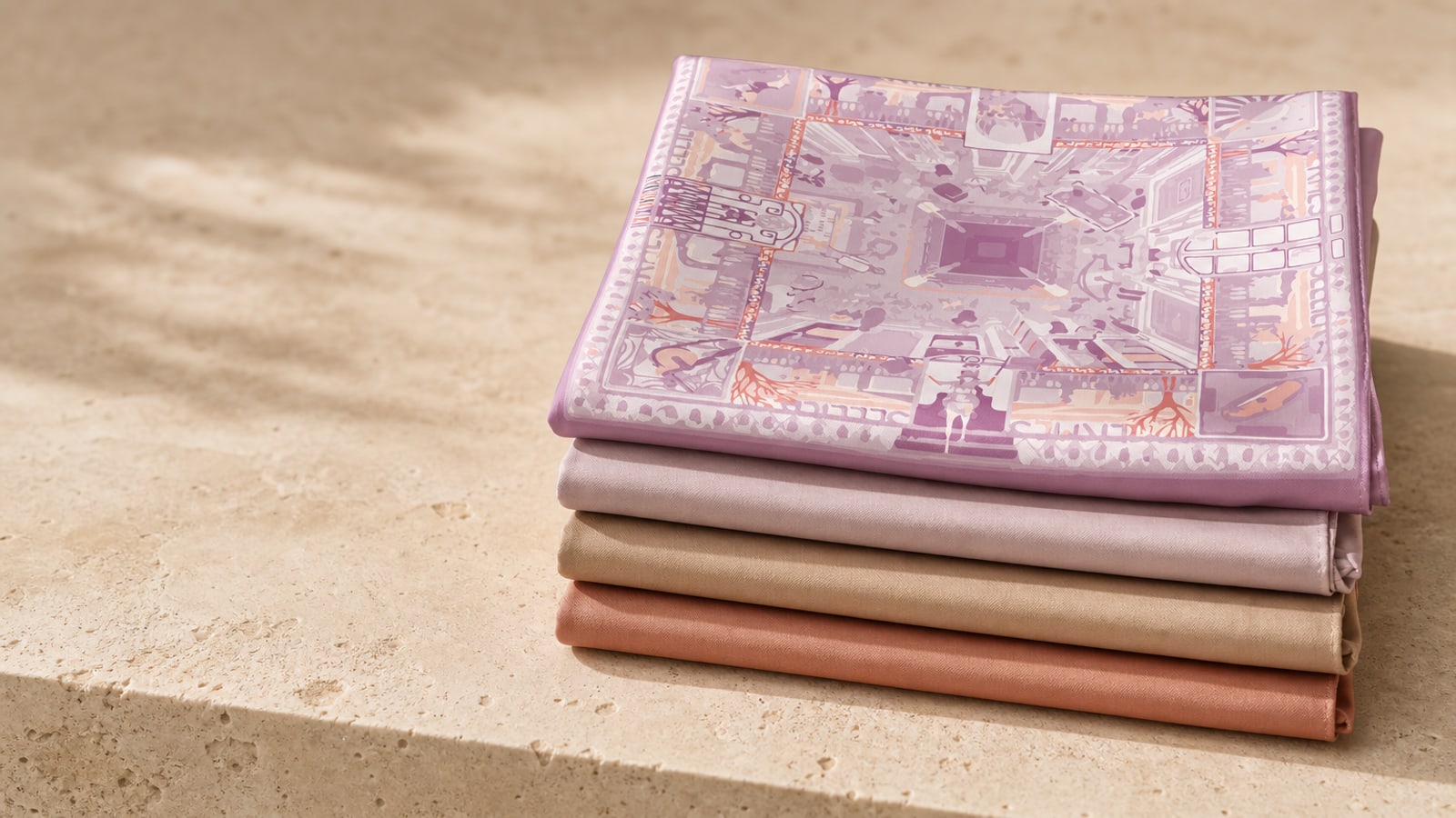 Folded silk scarves stacked on a travertine ledge